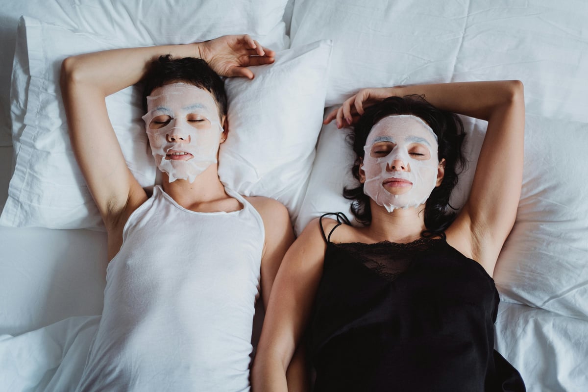 Two Women with Facial Masks in Bed